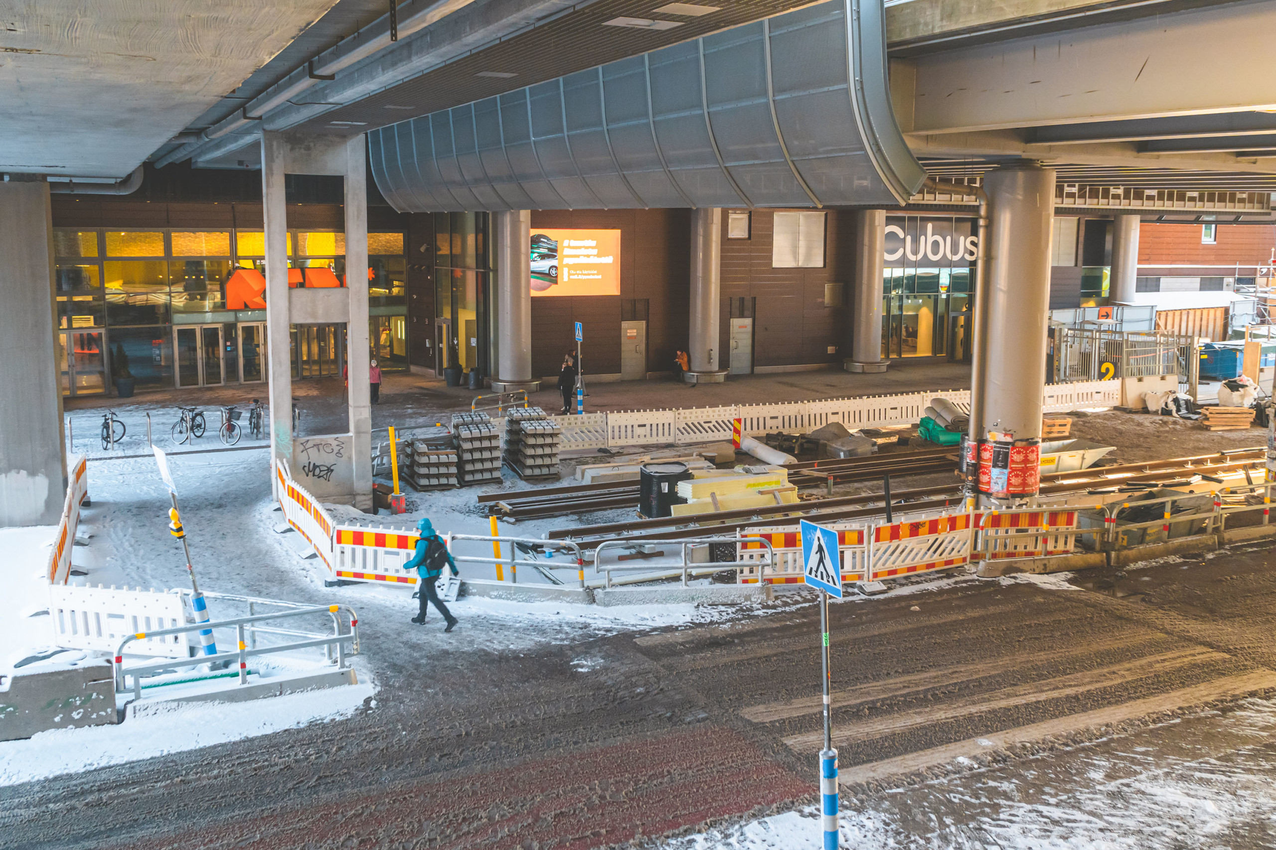 Raitiotiekiskojen asennustyöt käynnissä metroaseman ja Redin välissä sillan alla.